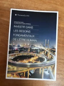 Deux prospectus ThomasLacyd sur fond bois, avec un visuel de viaduc et un titre sur les besoins fondamentaux.